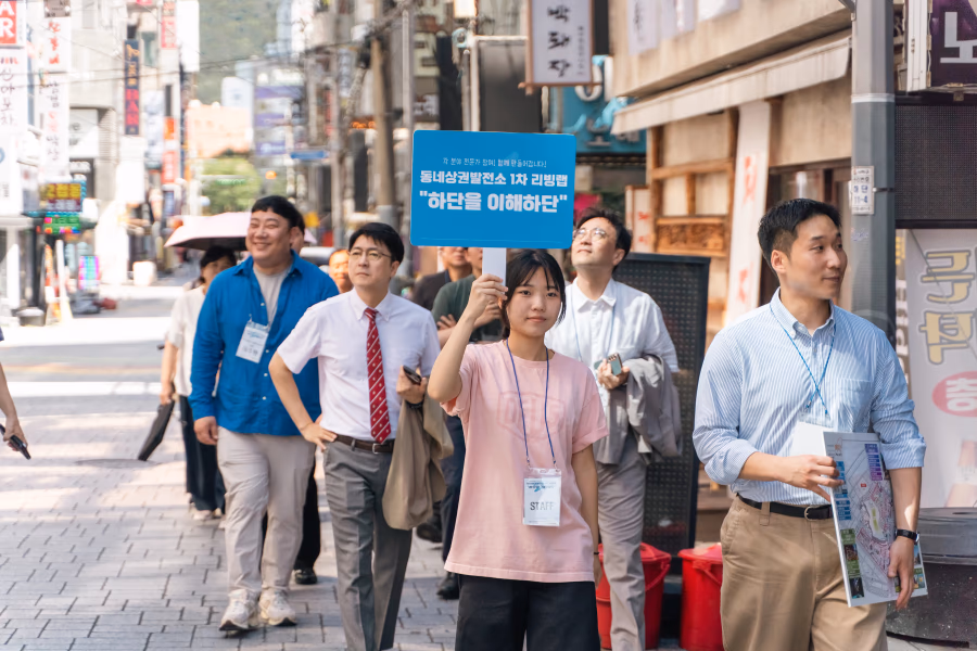 하리단길 1차 리빙랩, 참가자들이 안내물을 들고 상권 거리를 걷는 장면